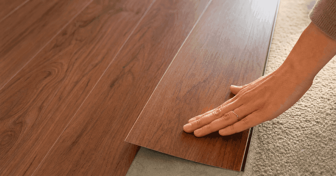 Rental bedroom with warm rosewood peel-and-stick vinyl plank flooring covering original beige vinyl tiles